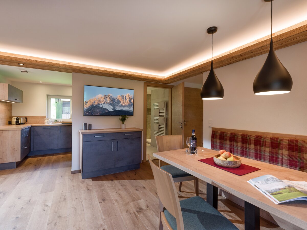 Moderne Küche und einladender Essbereich in einem Appartement, perfekt für gesellige Mahlzeiten in den Bergen.