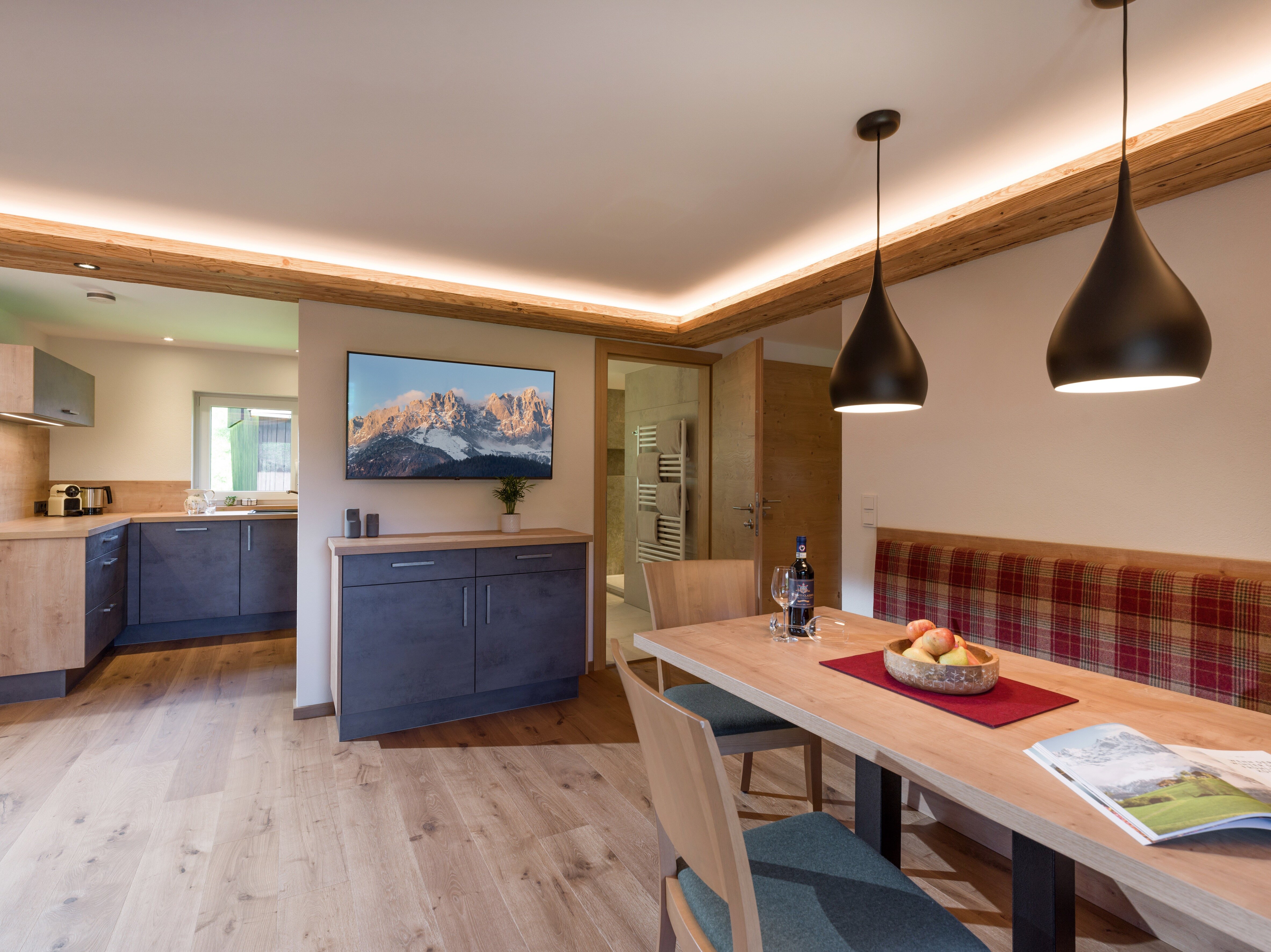 Moderne Küche und einladender Essbereich in einem Appartement, perfekt für gesellige Mahlzeiten in den Bergen.
